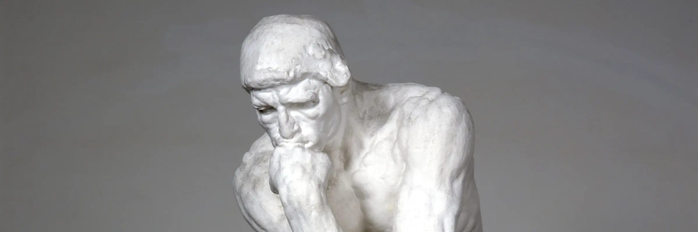 Skulptur eines sitzenden Mannes, Hand am Kinn