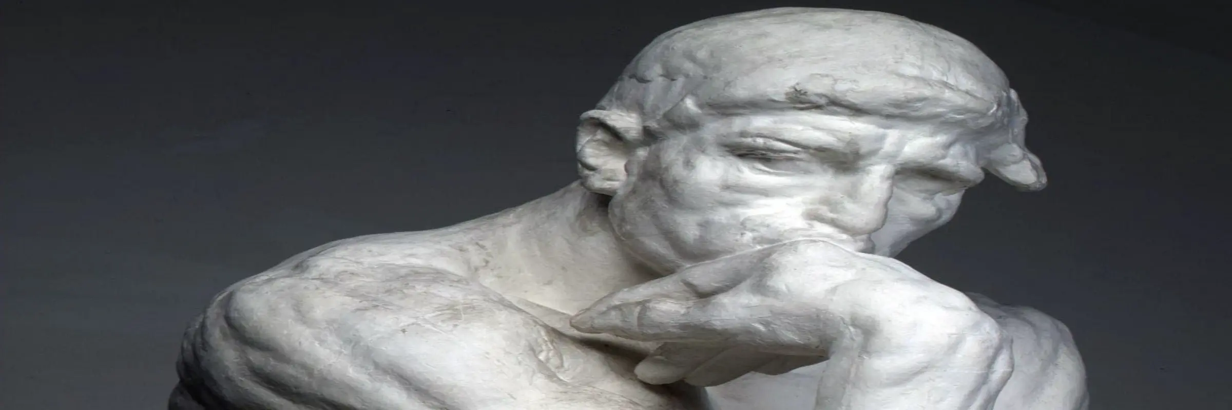 Eine Statue eines Mannes, der im Nachdenken seinen Kin auf den Faust stützt 