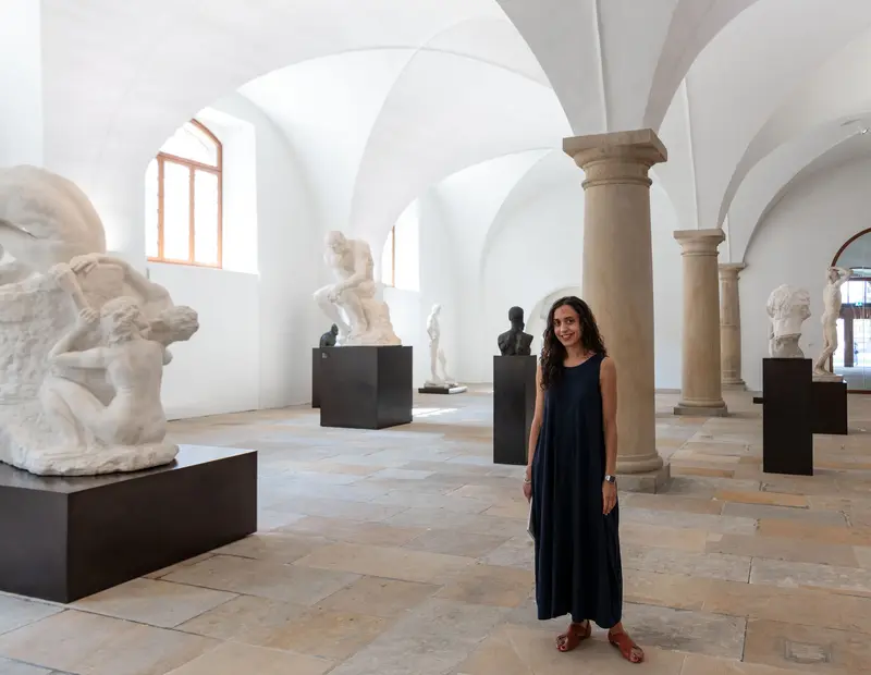 Frau in einer Halle neben Skulpturen