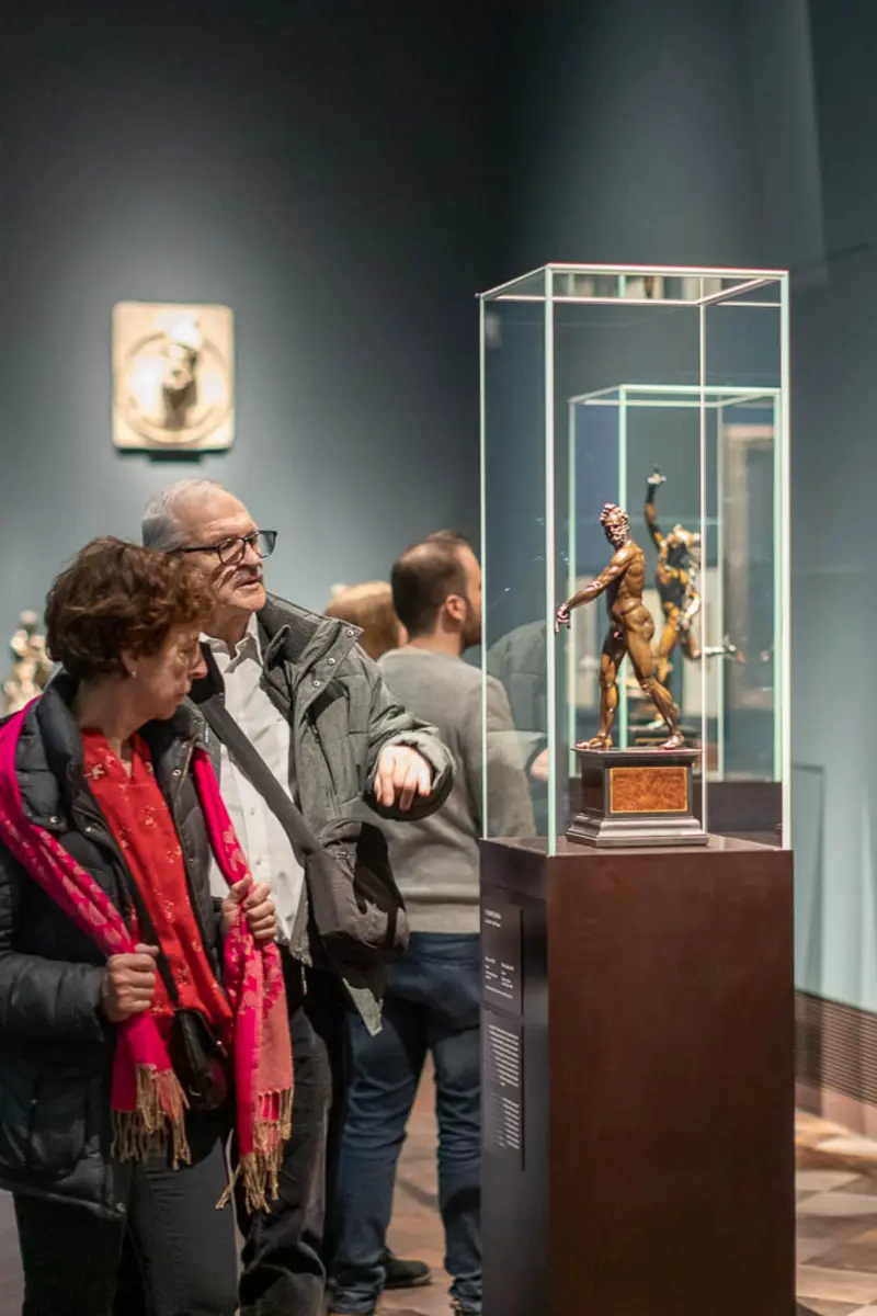 Ein Ehepaar schaut eine Bronzefigur an 