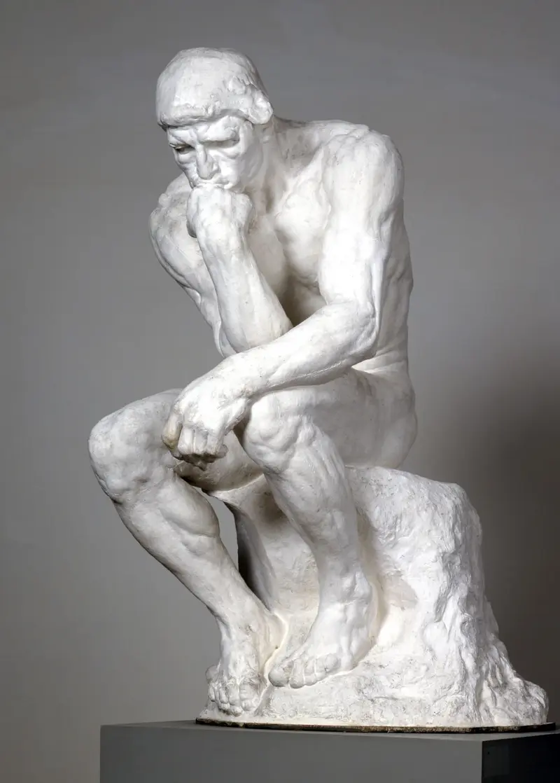 Eine Statue eines Mannes, der im Nachdenken seinen Kin auf den Faust stützt 