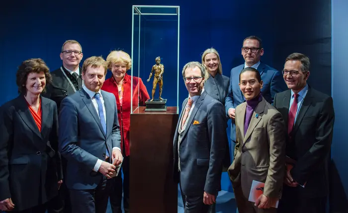 Personen um eine Statue